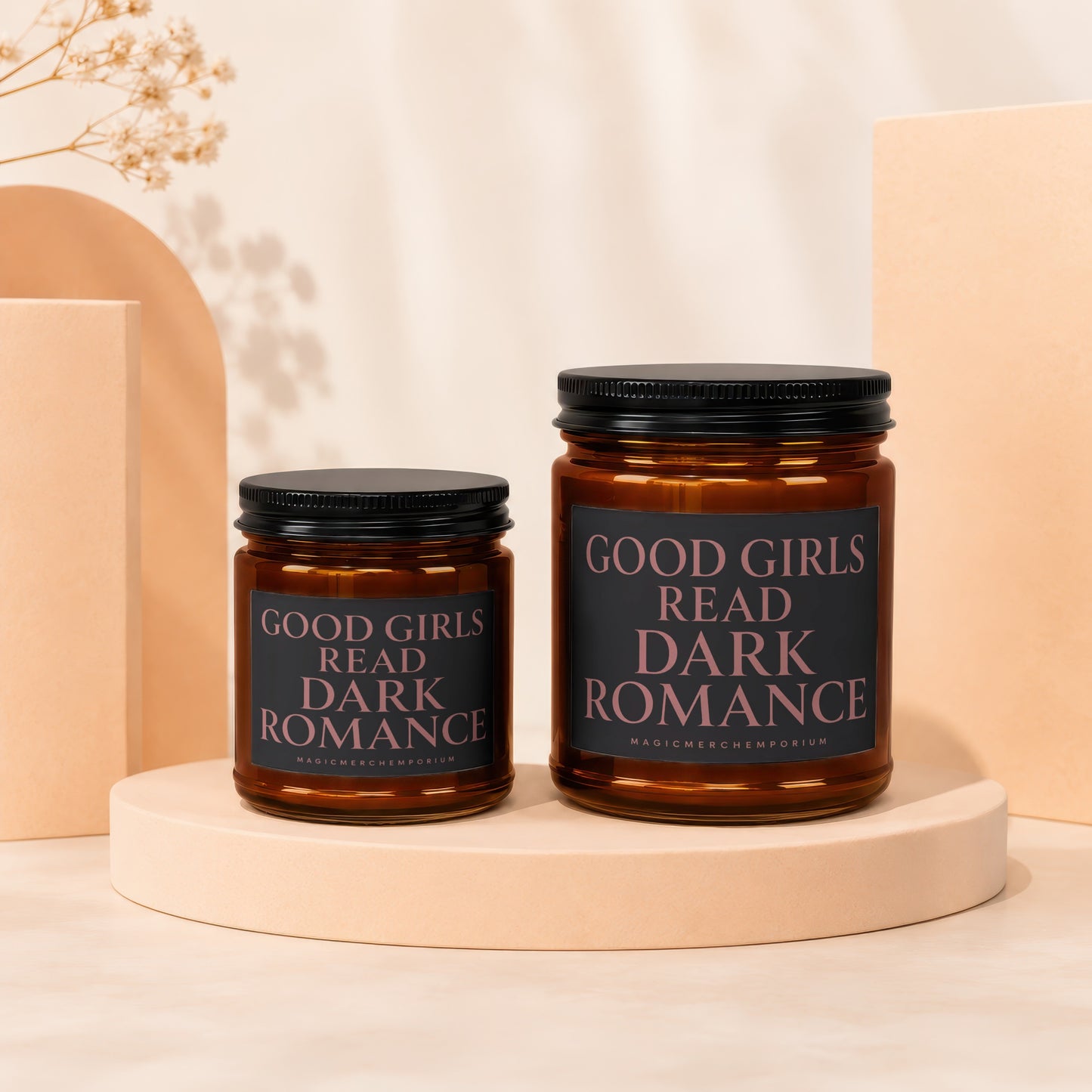 Two amber glass jars with black lids, bearing labels that read "Good Girls Read Dark Romance."