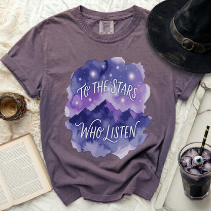 Purple t-shirt with "To the Stars Who Listen" graphic and starry mountains.