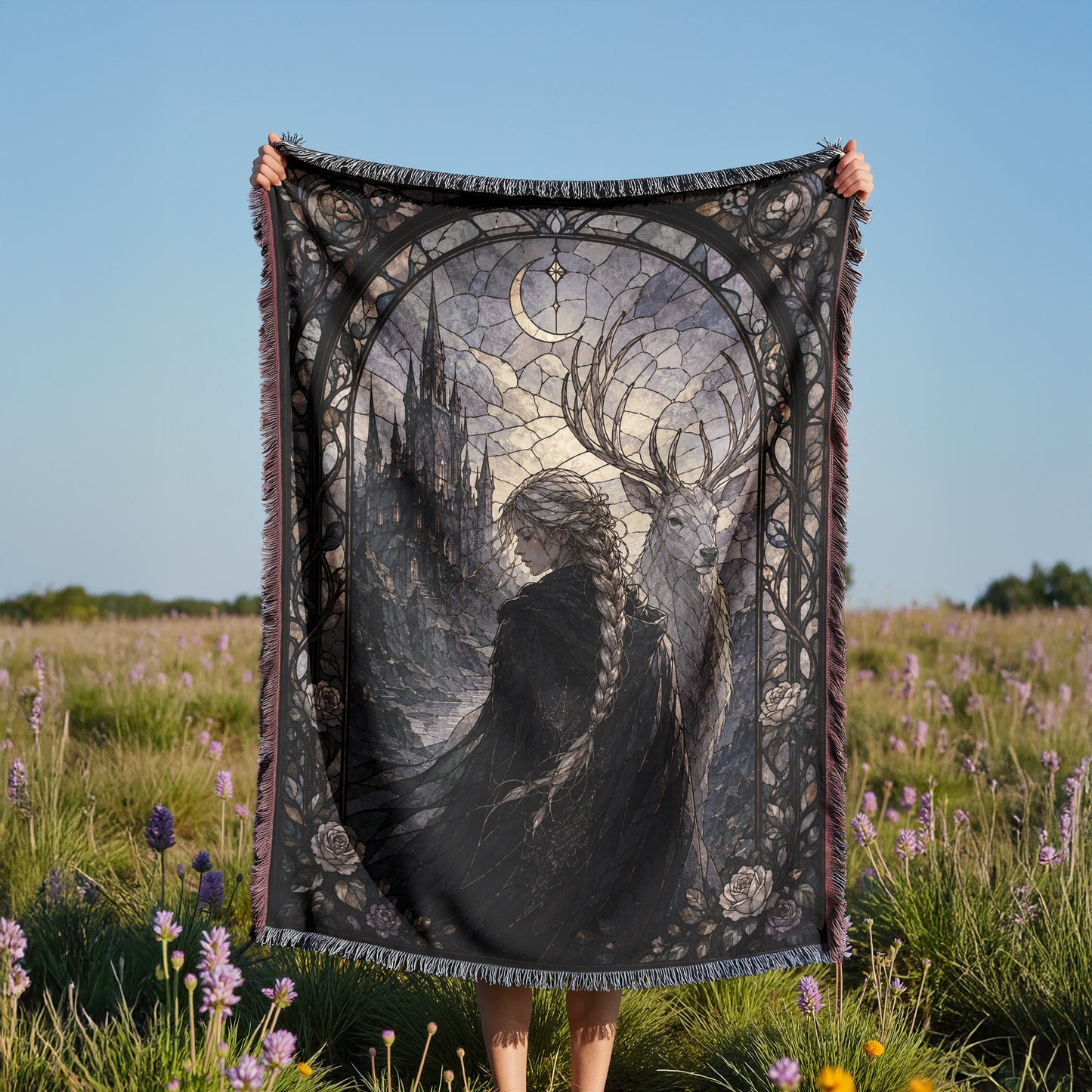 A person is holding up a large, ornate blanket with a detailed design featuring a woman and a castle in the background.