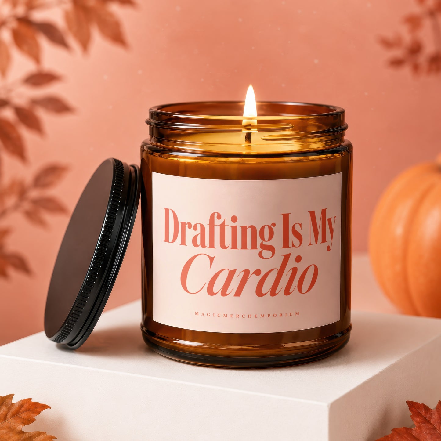 Amber candle with lid off, lit wick, autumn decor, reads "Drafting Is My Cardio".