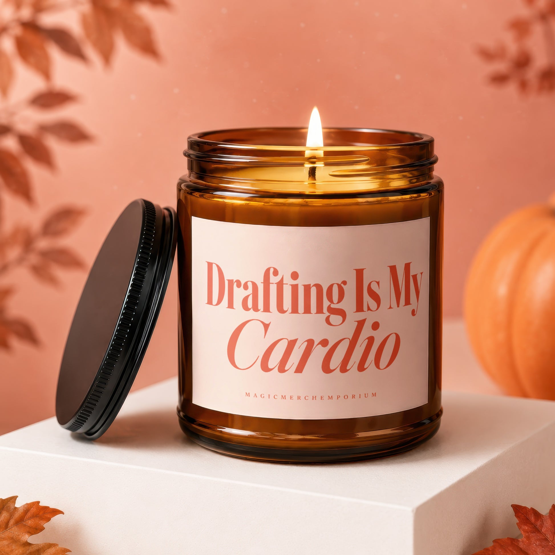 Amber candle with lid off, lit wick, autumn decor, reads "Drafting Is My Cardio".