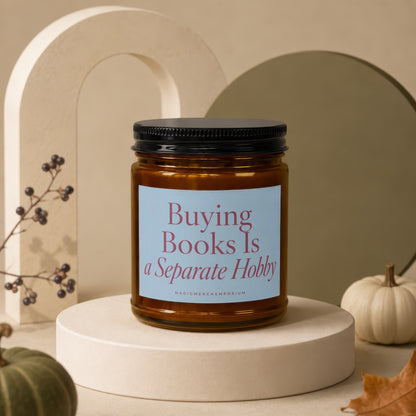 Amber candle with black lid labeled "Buying Books Is a Separate Hobby".