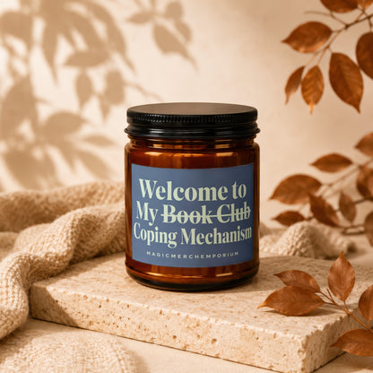 Amber jar candle with a blue label reading "Welcome to My Book Club Coping Mechanism".
