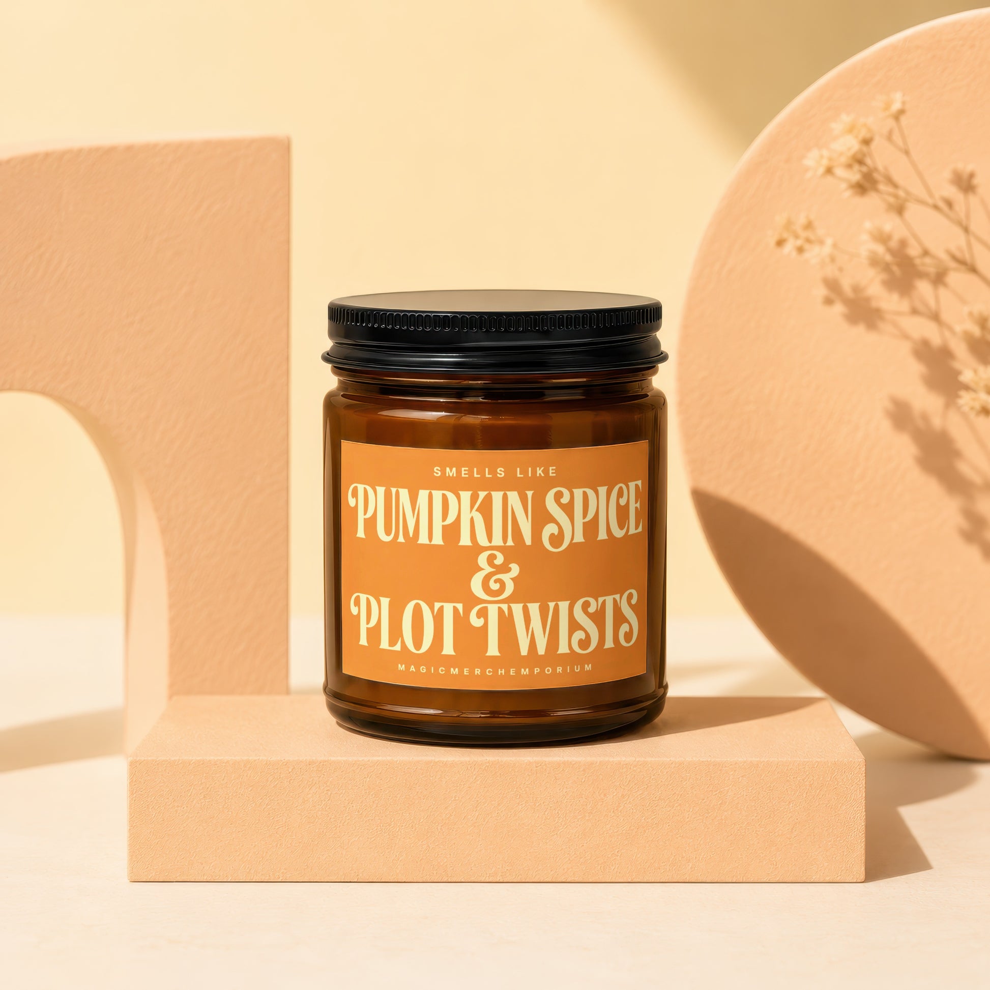 Amber glass candle with "Pumpkin Spice & Plot Twists" label.