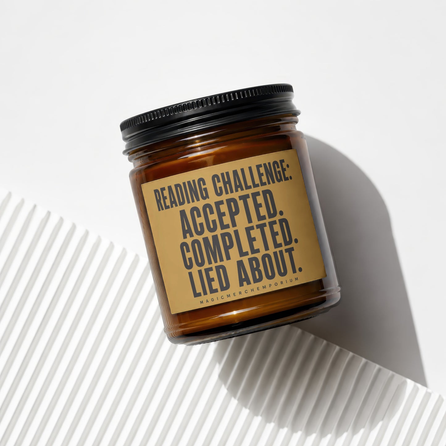 Amber jar candle with black lid, label reads "Reading Challenge: Accepted. Completed. Lied About."