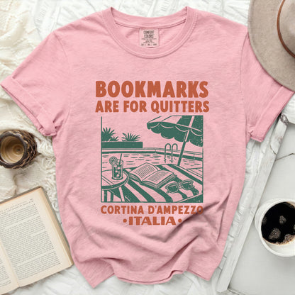 Pink t-shirt with "BOOKMARKS ARE FOR QUITTERS" and Italian town graphic.