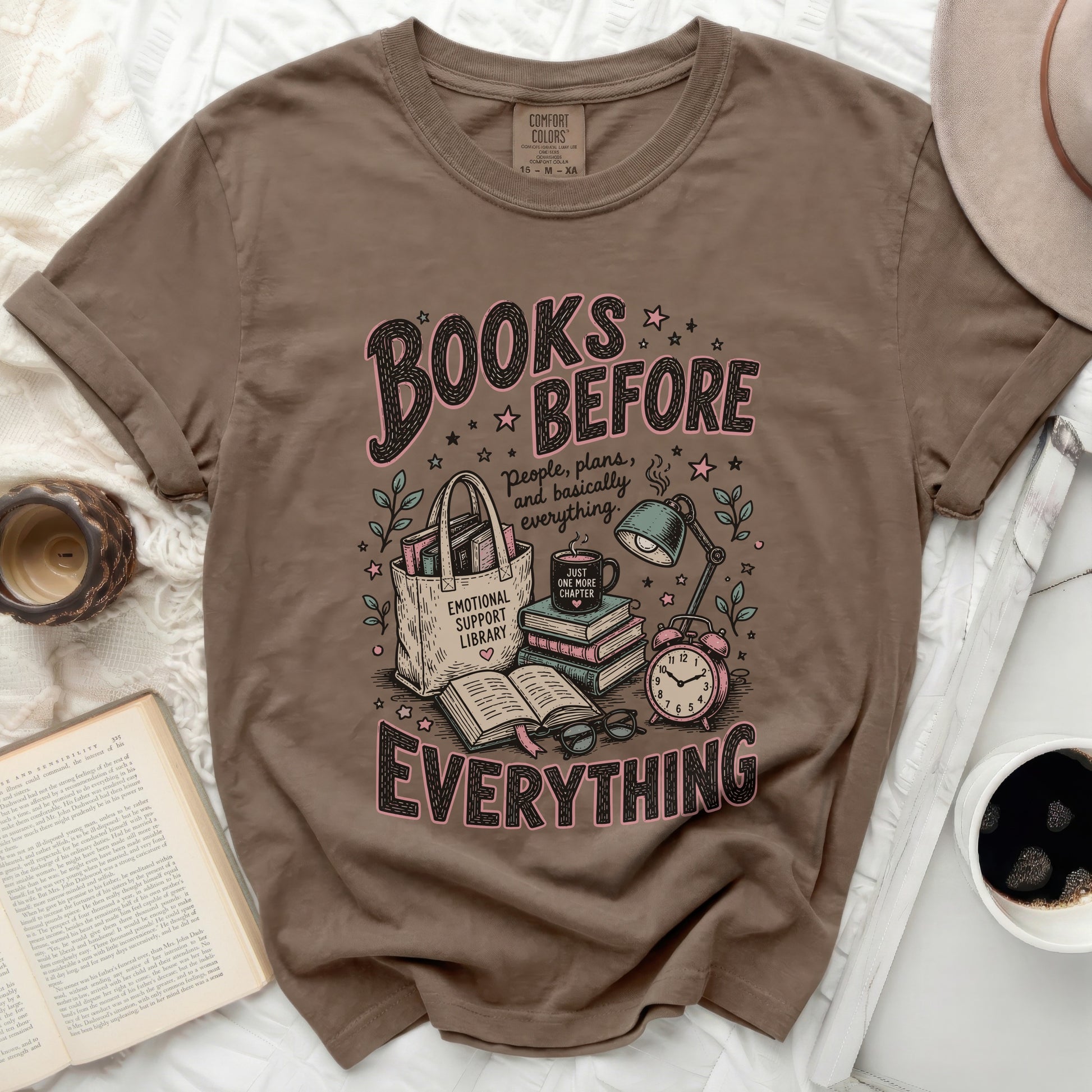 Brown t-shirt with "Books Before Everything" graphic and reading motif.