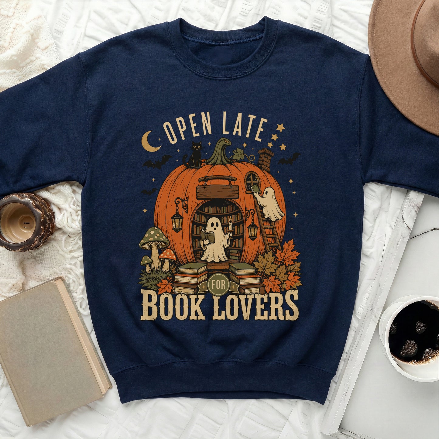 Navy sweatshirt with "Open Late For Book Lovers" and a Halloween-themed pumpkin library design.
