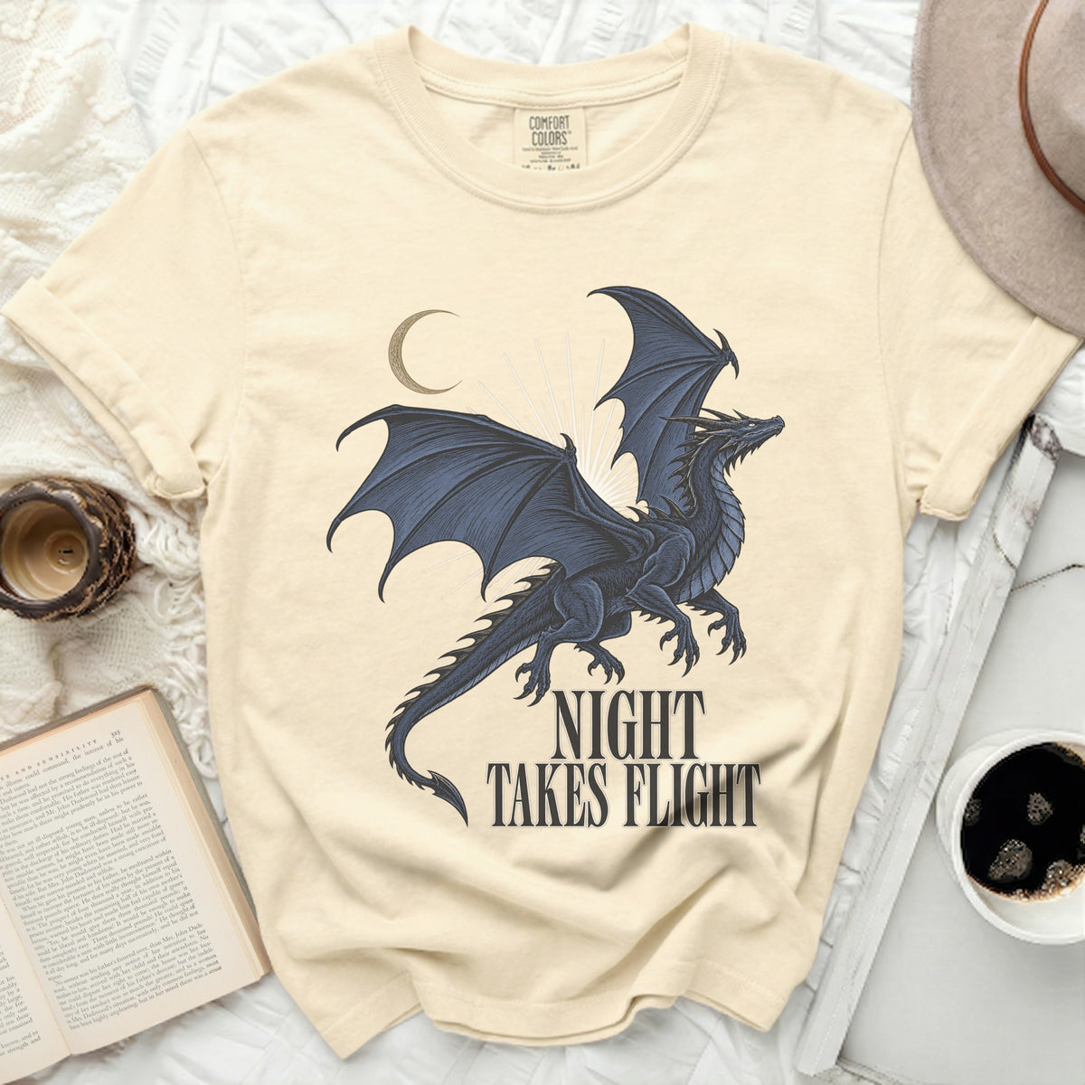 Cream t-shirt with a black dragon design and text "NIGHT TAKES FLIGHT".