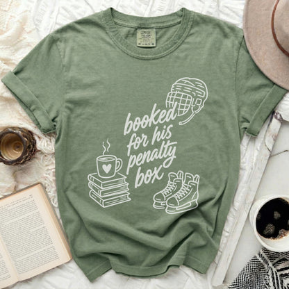 Green t-shirt with "booked for his penalty box" text and hockey imagery.
