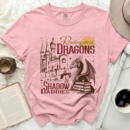 Pink t-shirt with dragon, castle, books, and "Reading about Dragons & Shadow Daddies" text.