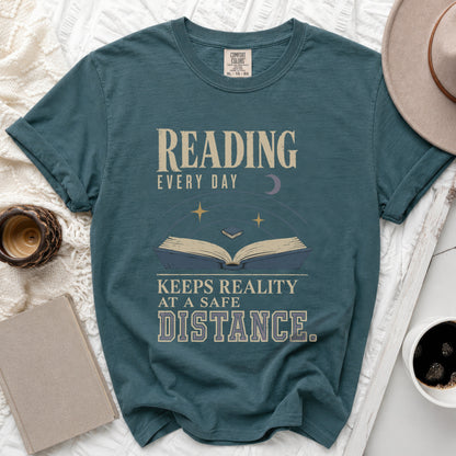 Teal t-shirt with "Reading Every Day Keeps Reality At A Safe Distance" text.