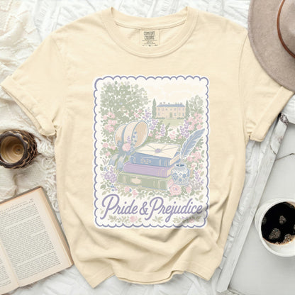 Cream t-shirt with Pride & Prejudice illustration of books and manor.