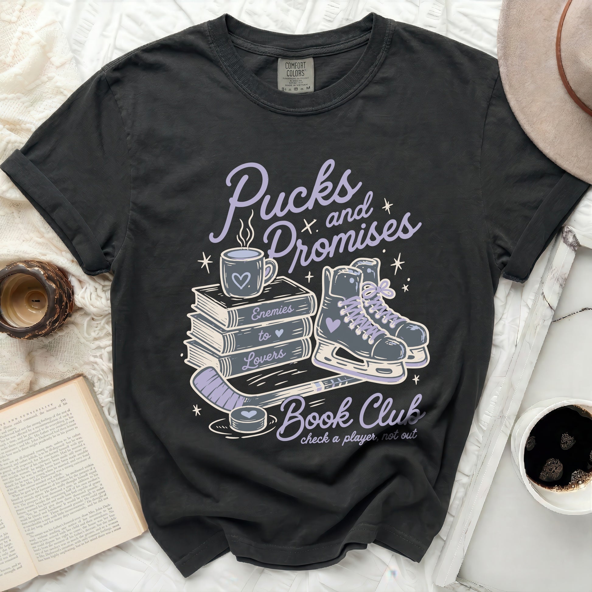 Black t-shirt with "Pucks and Promises Book Club" graphic and skates.