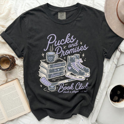 Black t-shirt with "Pucks and Promises Book Club" graphic and skates.