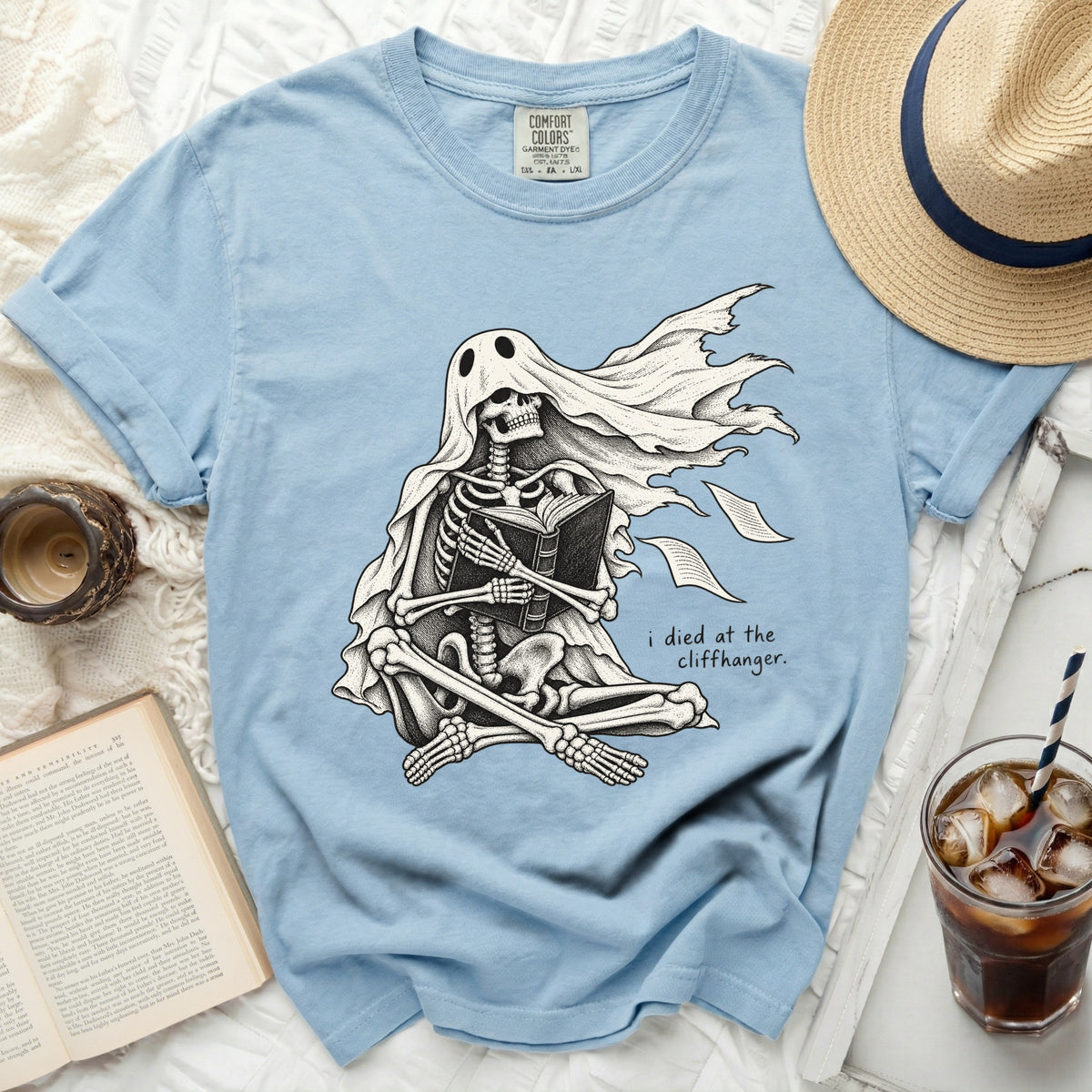 Skeleton ghost reading a book with the text "i died at the cliffhanger."