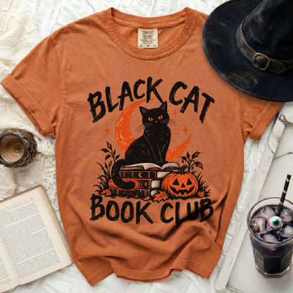 Orange t-shirt with black cat, crescent moon, pumpkin, and "BLACK CAT BOOK CLUB" text.