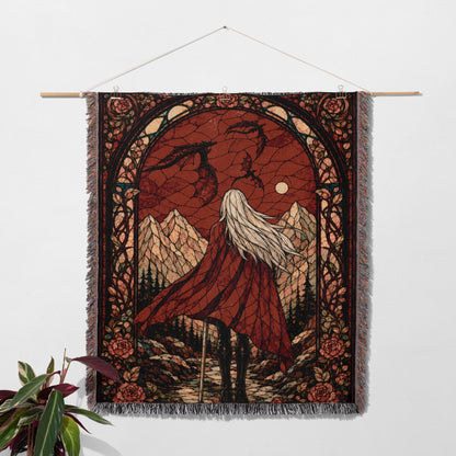 a tapestry hanging on a wall, depicting a woman with long hair standing in a mountainous landscape under a night sky.
