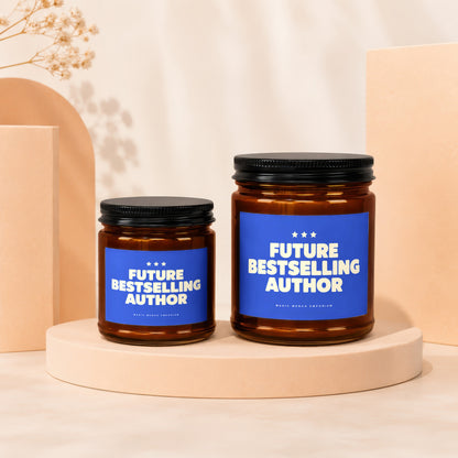 Two amber glass candles with black lids on cream display, reading "Future Bestselling Author".
