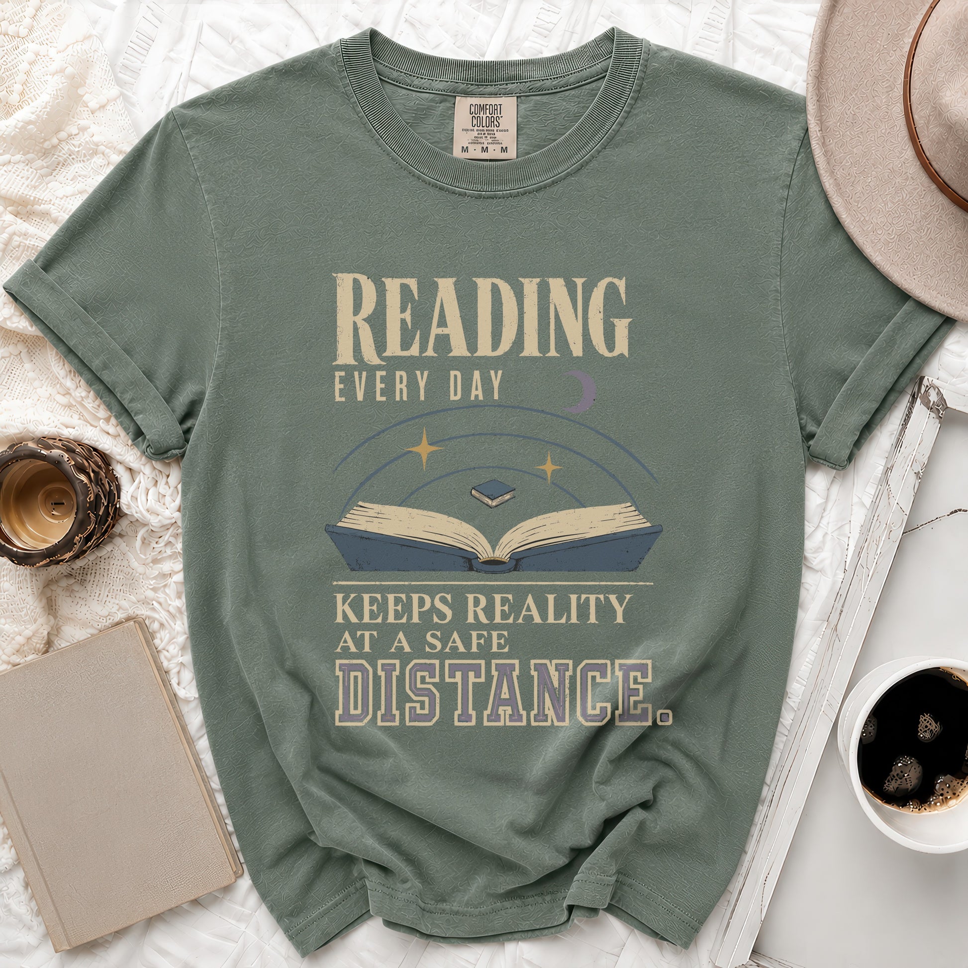 Green t-shirt with "Reading Every Day Keeps Reality At A Safe Distance" text and an open book.