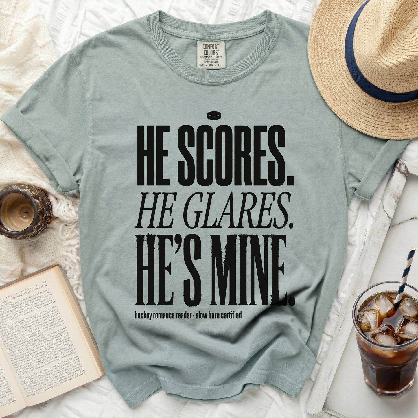 Light blue t-shirt with "He scores. He glares. He's mine." text.