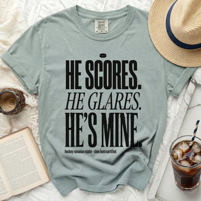 Light blue t-shirt with "He scores. He glares. He's mine." text.