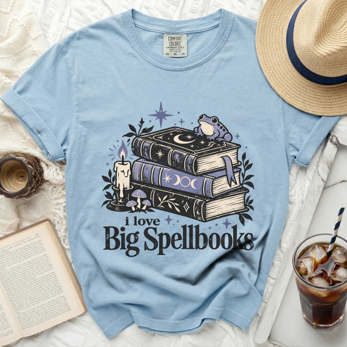 Light blue t-shirt with "i love Big Spellbooks" graphic featuring books, frog, and candle.