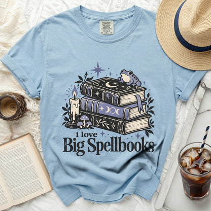 Light blue t-shirt with "i love Big Spellbooks" graphic featuring books, frog, and candle.