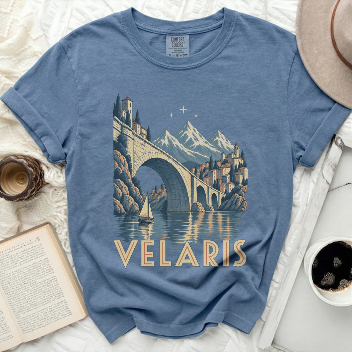 Blue t-shirt with Velaris text and an arched bridge over water with mountains.