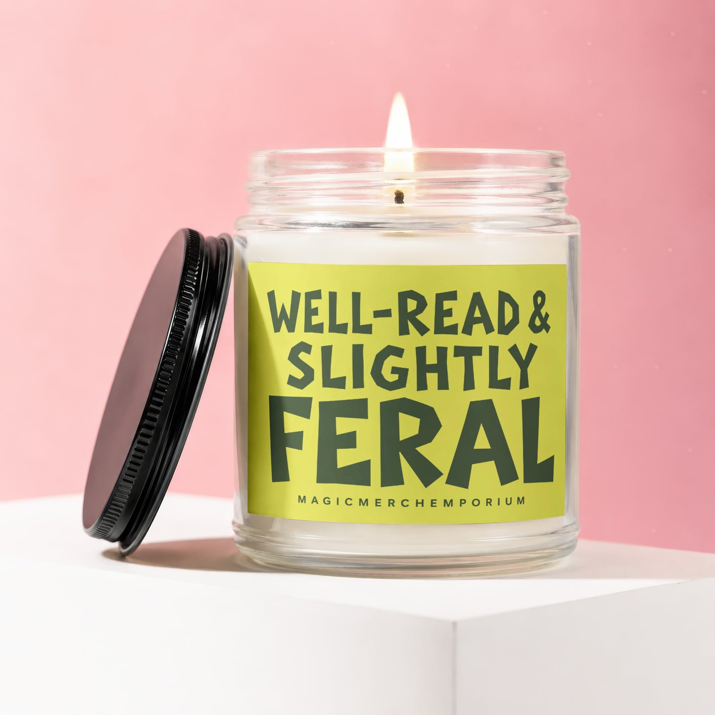Lit glass jar candle with label reading "Well-Read & Slightly Feral".