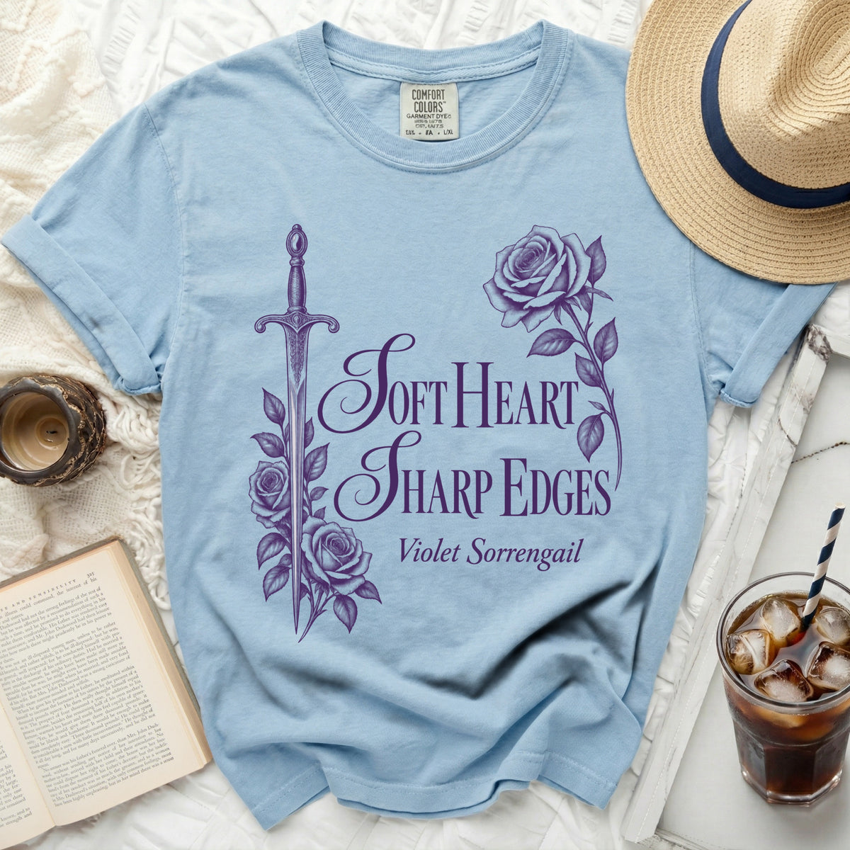 Light blue t-shirt with purple sword, rose, and "Soft Heart Sharp Edges" text.