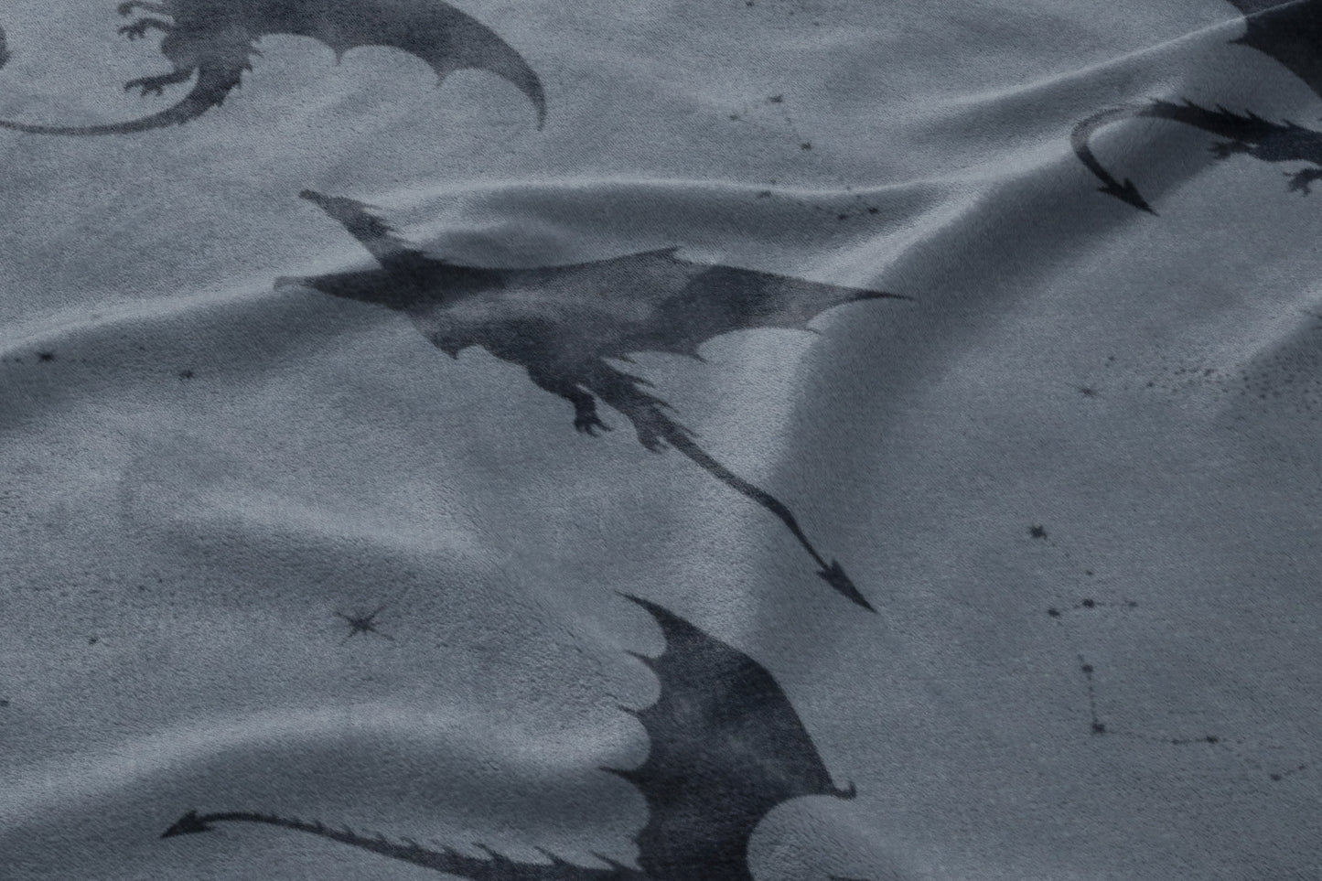Dark dragons with wings are patterned across a rumpled grey fabric with small star details.