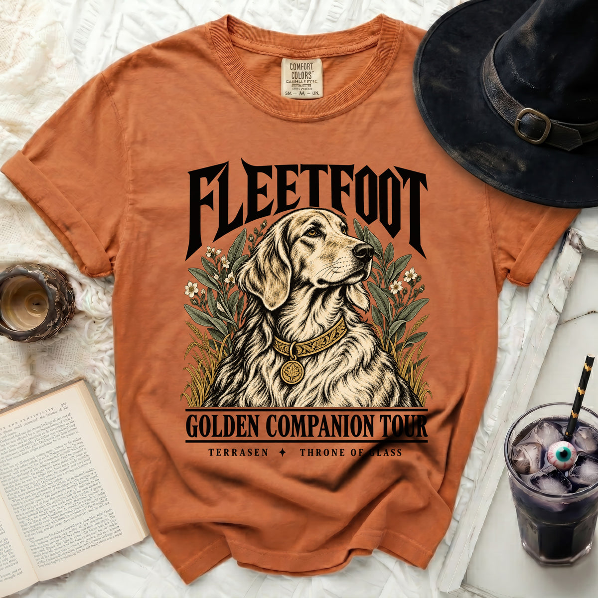 Orange t-shirt with "FLEETFOOT GOLDEN COMPANION TOUR TERRASEN THRONE OF GLASS" and dog graphic.