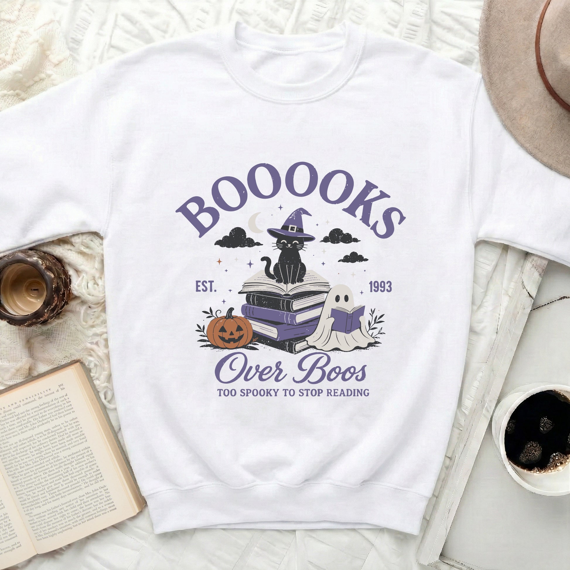 White sweatshirt with "BOOOOKS Over Boos" Halloween graphic.
