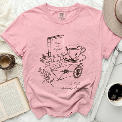 Pink shirt with line art of "Pride and Prejudice" book, teacup, envelope, and cameo.