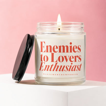 Candle with "Enemies to Lovers Enthusiast" text on label, black lid beside it.