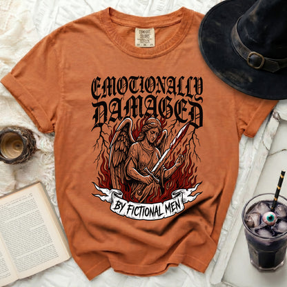 Orange t-shirt with "Emotionally Damaged by Fictional Men" graphic.