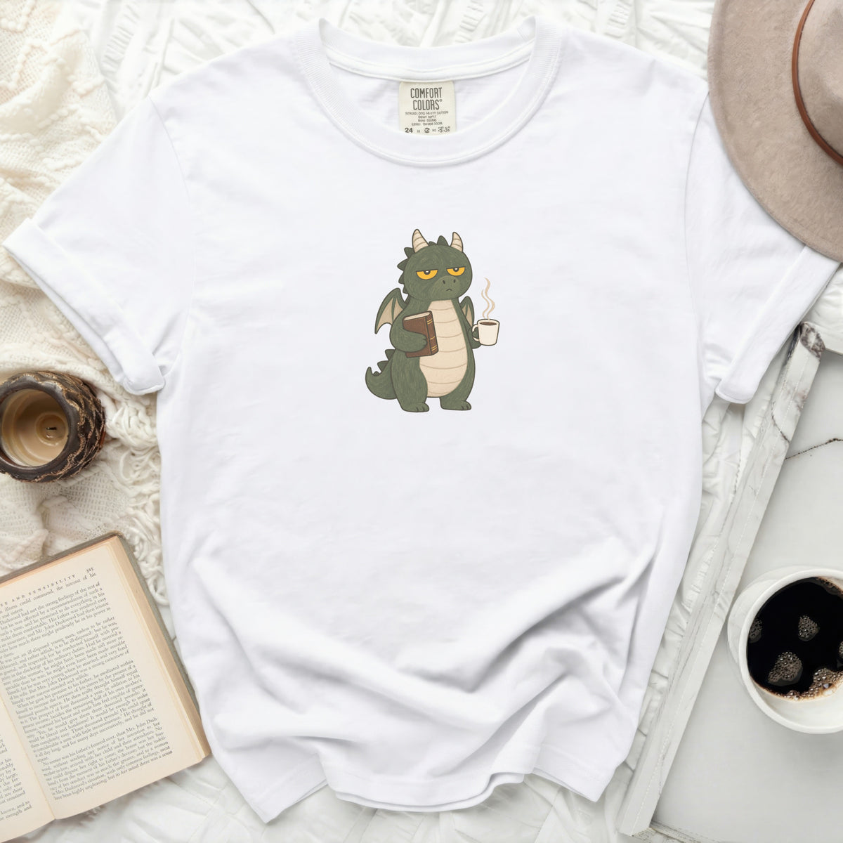 White t-shirt with green dragon holding a book and coffee mug.