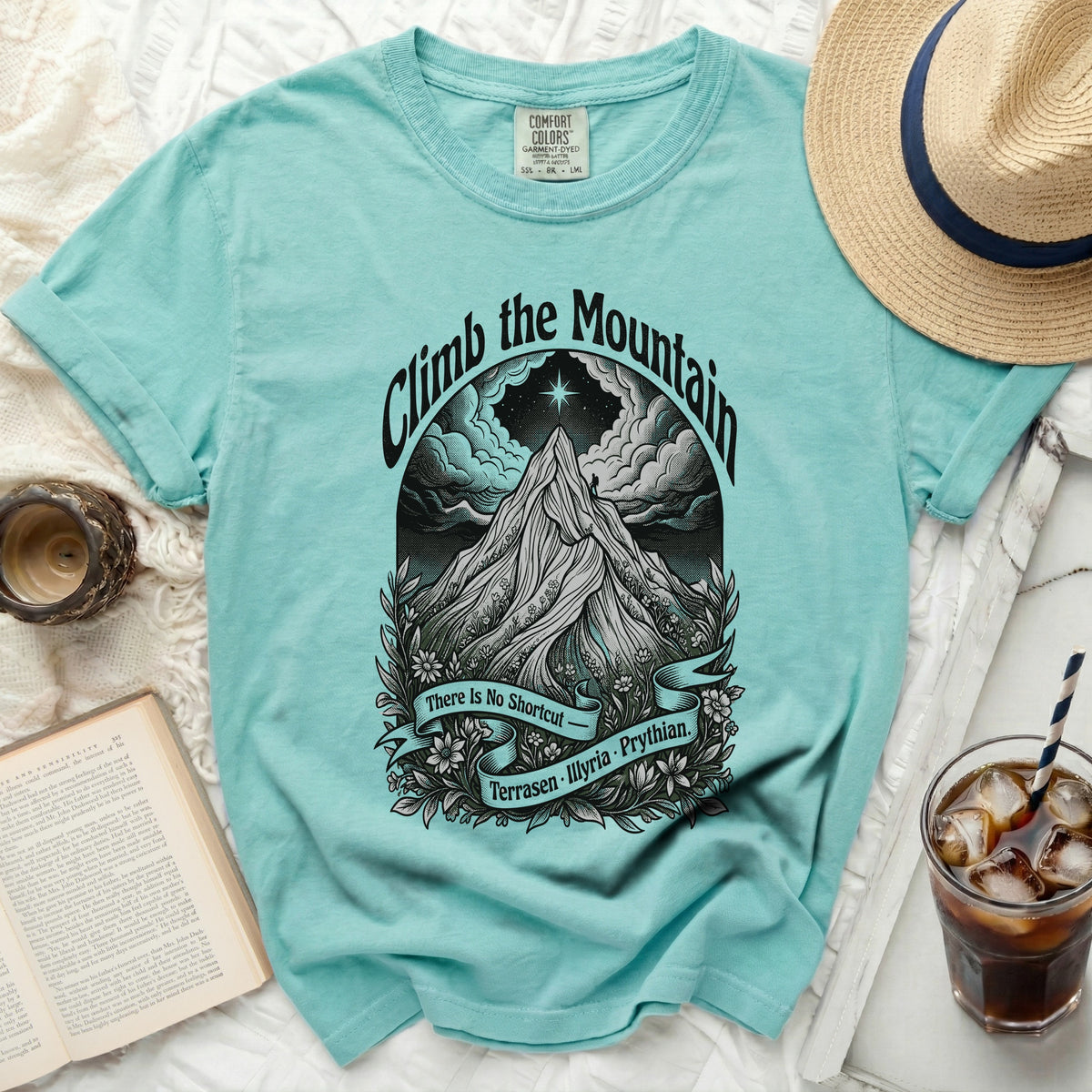 Turquoise t-shirt with "Climb the Mountain" and mountain graphic.