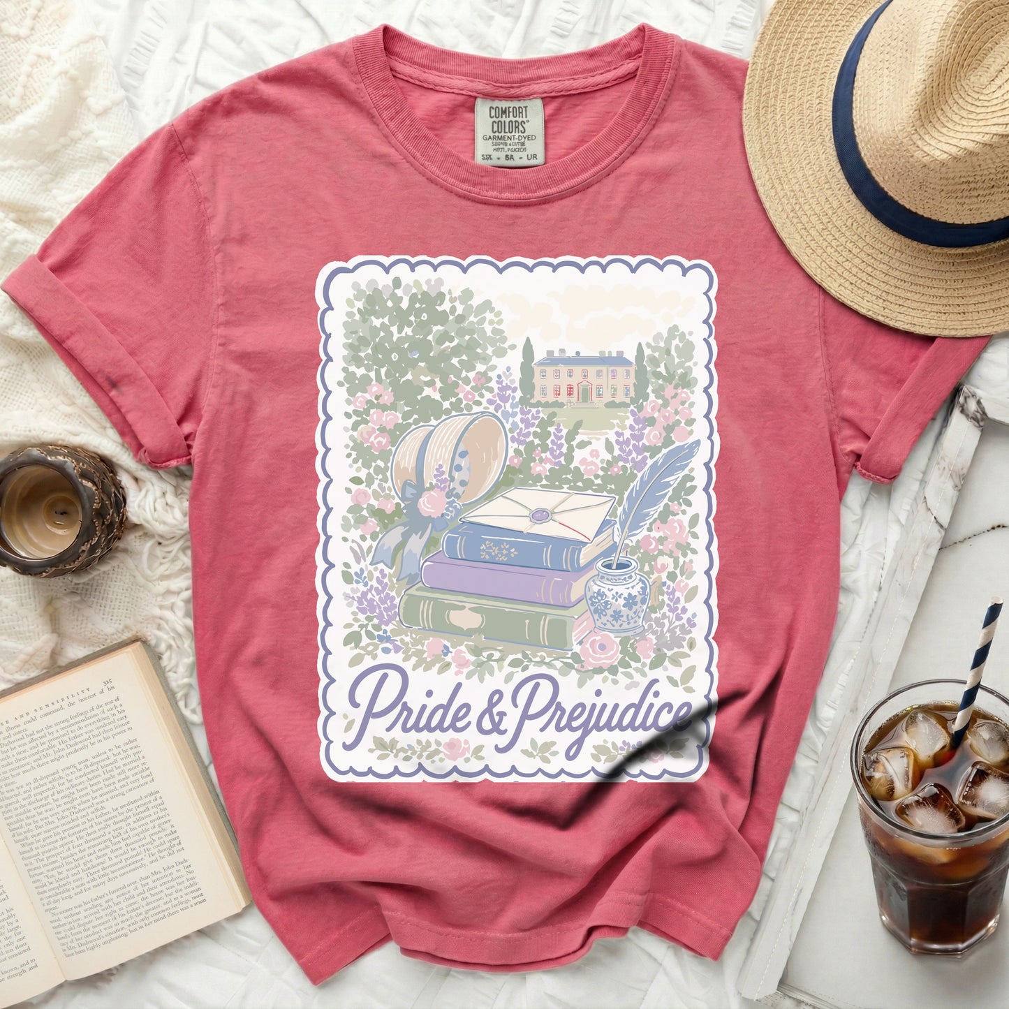 T-shirt with "Pride & Prejudice" embroidered garden scene and stack of books.