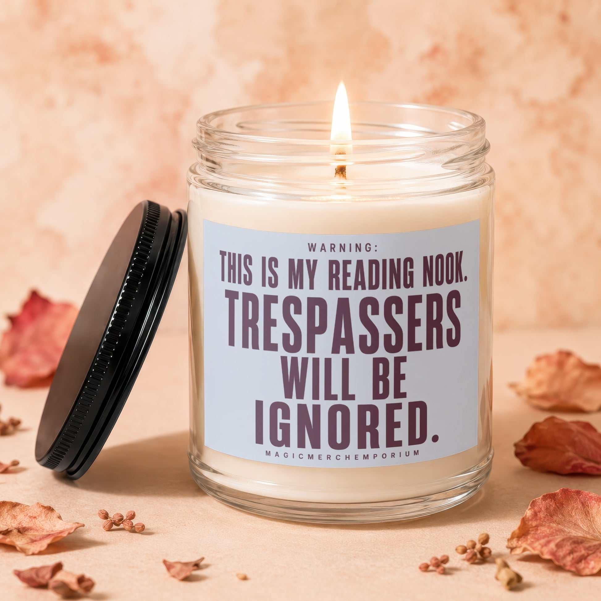 Candle with lit wick and label reading "Warning: This is my reading nook. Trespassers will be ignored."