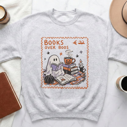 "Books Over Boos" graphic with ghost, books, pumpkin, and coffee mug on sweatshirt.