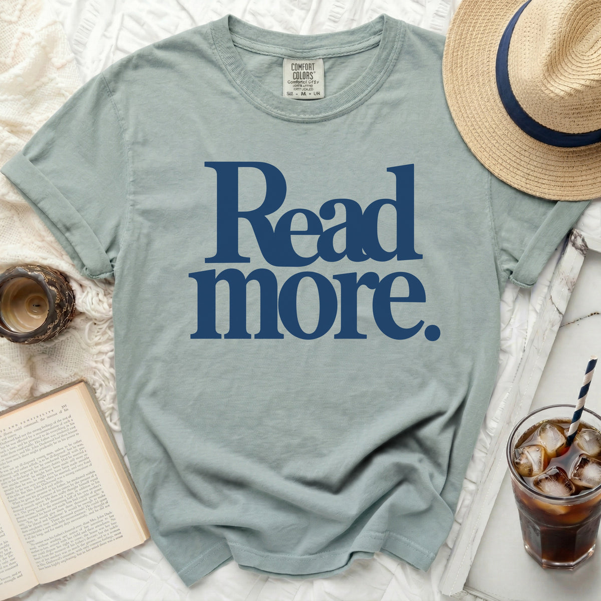 Sage green t-shirt with navy blue "Read more." graphic.