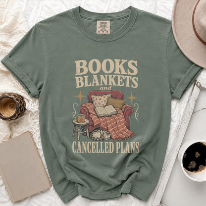 Sage green t-shirt with "Books Blankets and Cancelled Plans" text and vintage graphic.