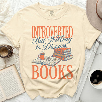 Cream t-shirt with "Introverted But Willing To Discuss Books" text and book illustration.