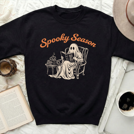 Black sweatshirt with a ghost reading a book and text "Spooky Season".