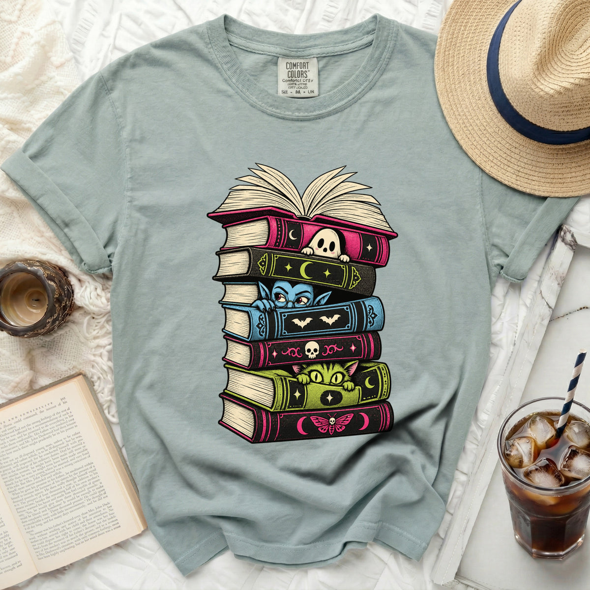 T-shirt with stack of books and spooky cartoon characters.