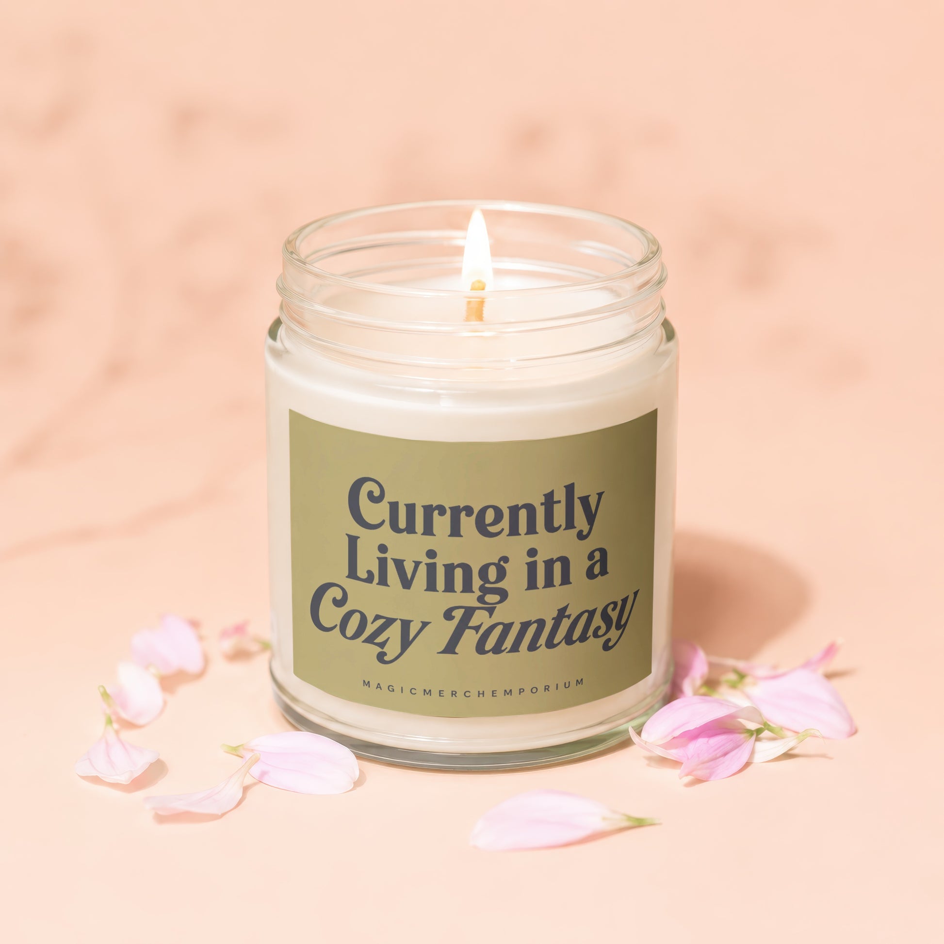Candle with text "Currently Living in a Cozy Fantasy" and brand "MAGICMERCHTEMPORIUM".