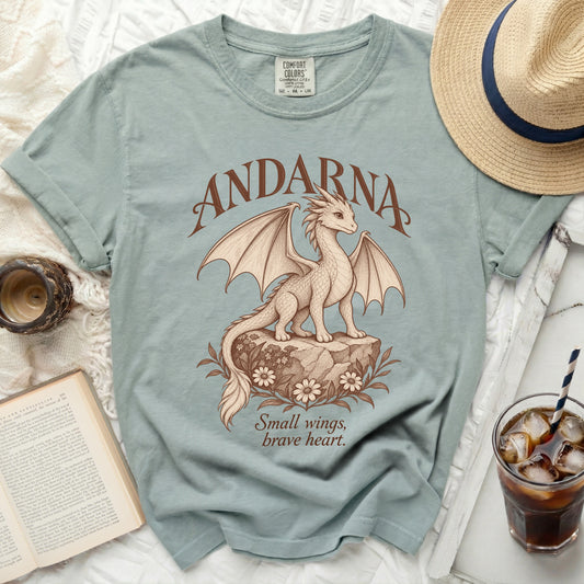 Light blue t-shirt with a dragon design and text "ANDARNA" and "Small wings, brave heart."