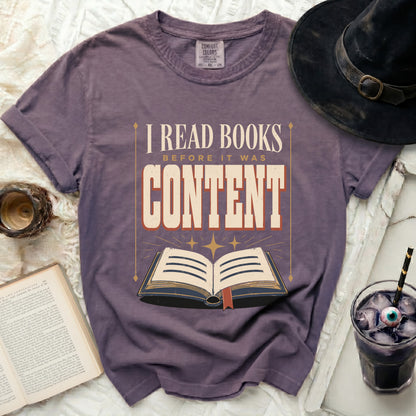 Purple t-shirt with "I READ BOOKS BEFORE IT WAS CONTENT" text and open book graphic.